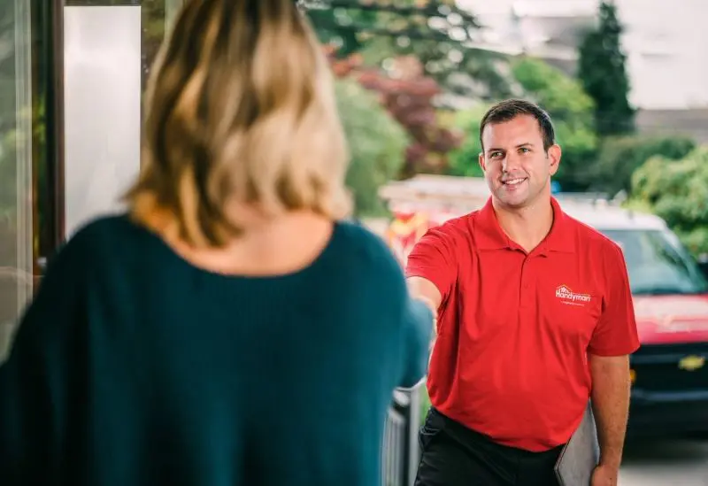 A Mr. Handyman technician being greeted by a customer.