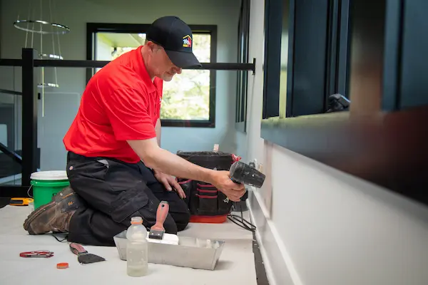 An MRH patching drywall in a home.