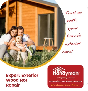 Couple sitting on lawn with dog outside wooden house.