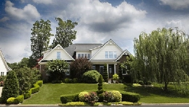 White home with manicured landscaping White home with manicured landscaping
